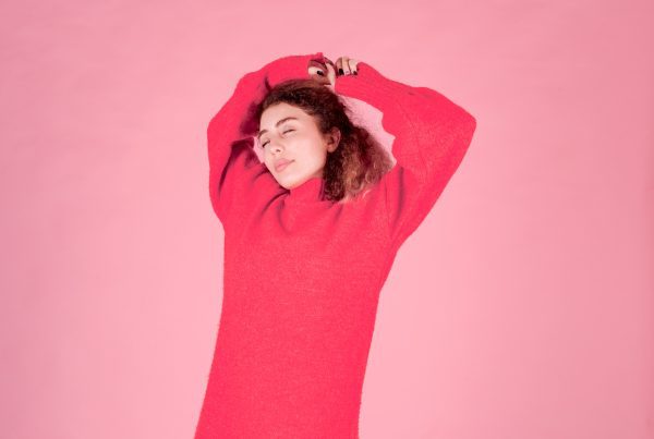 Cervicale, una ragazza con maglione rosso
