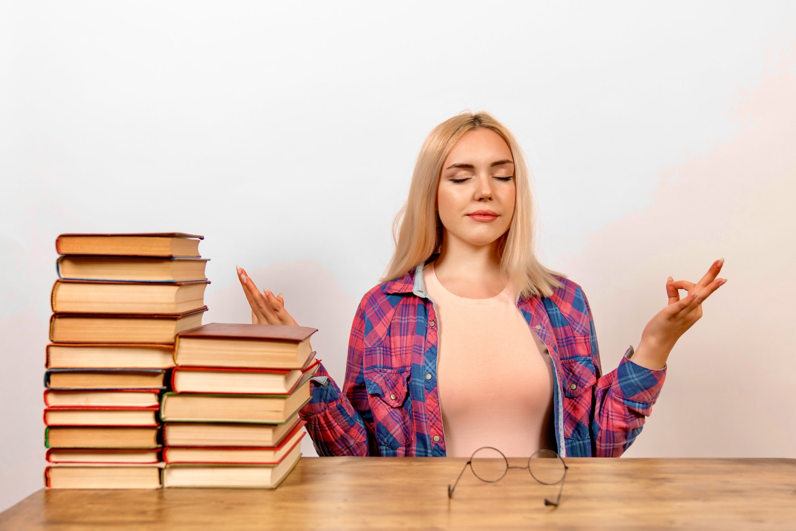 Errori grammaticali, una ragazza con dei libri medita contro lo stress