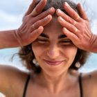 una donna con le mani in testa ha vampate di calore