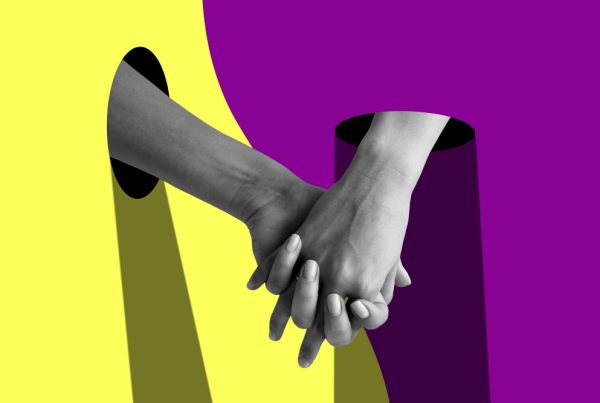Psicologia e Fiducia negli altri: 2 mani si prendono sullo sfondo di due colori diversi